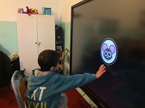 Kyle reaching out towrds the object on screen..