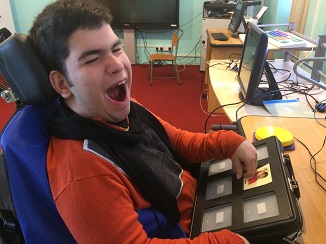 Manuel laughing while saying hello on the Symbol Talker.